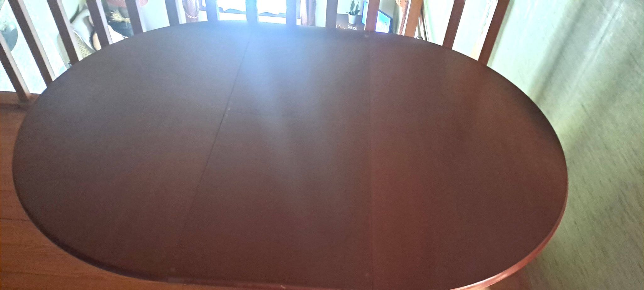 Round solid walnut table with central leg from the 1950s with extensions.