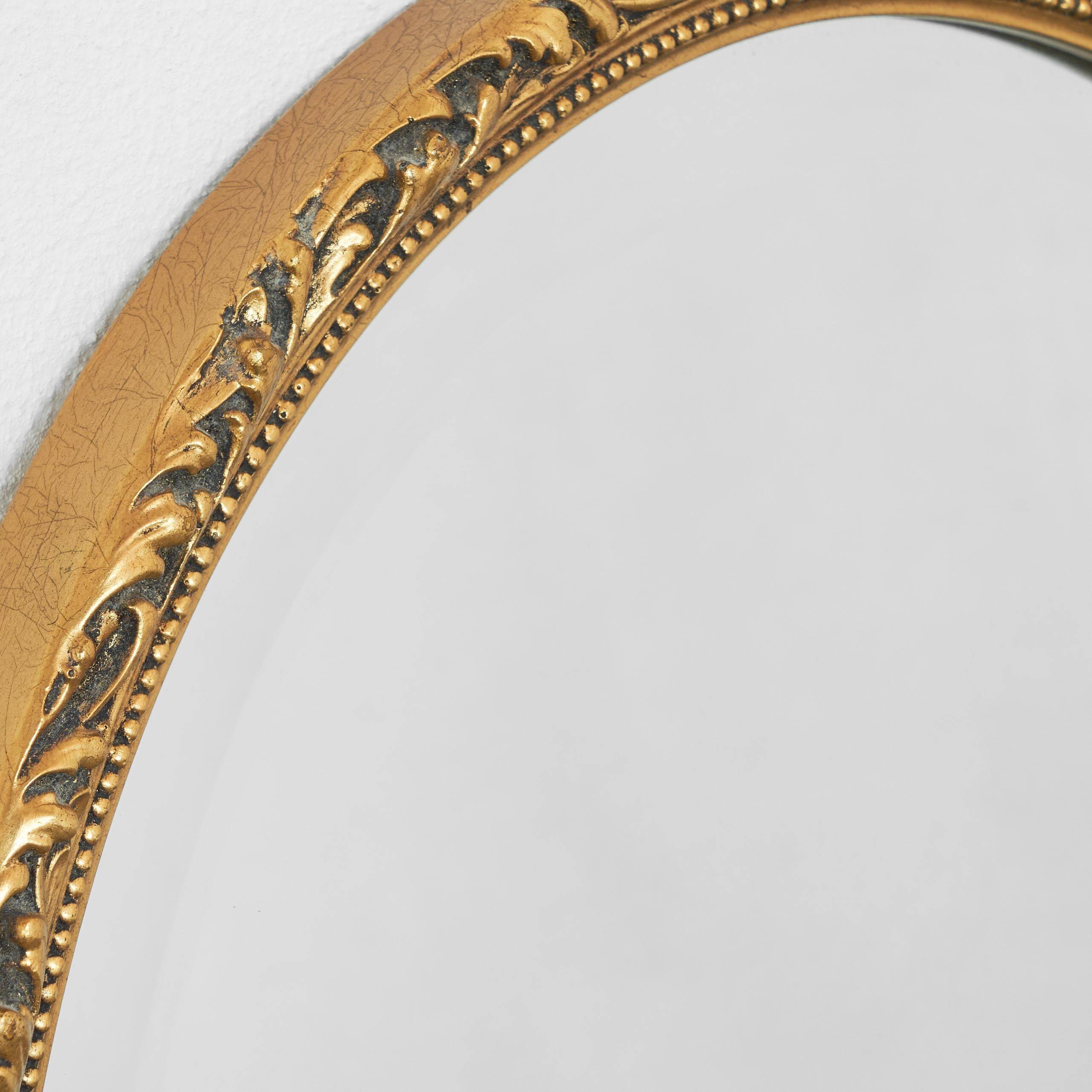 Oval mirror with gilded wood from the 1960s.