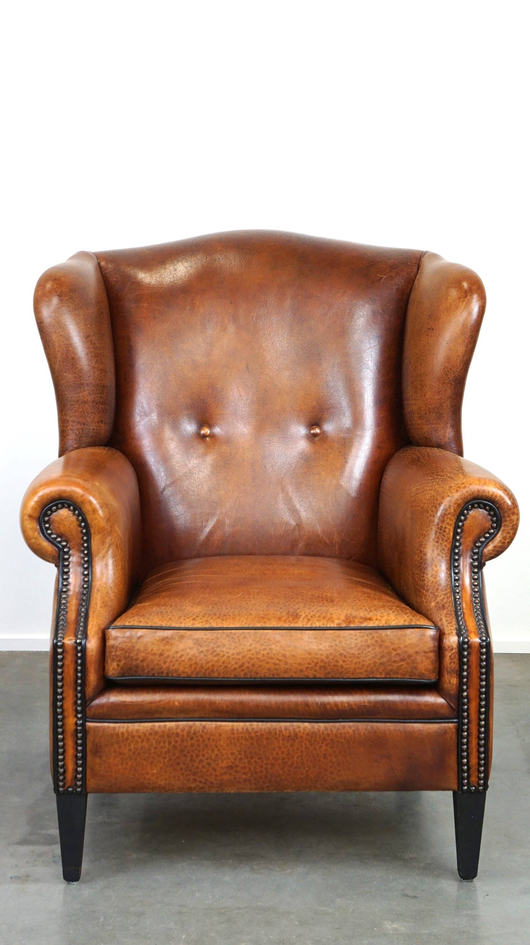 Sheepskin leather wingback armchair, with nails and black piping