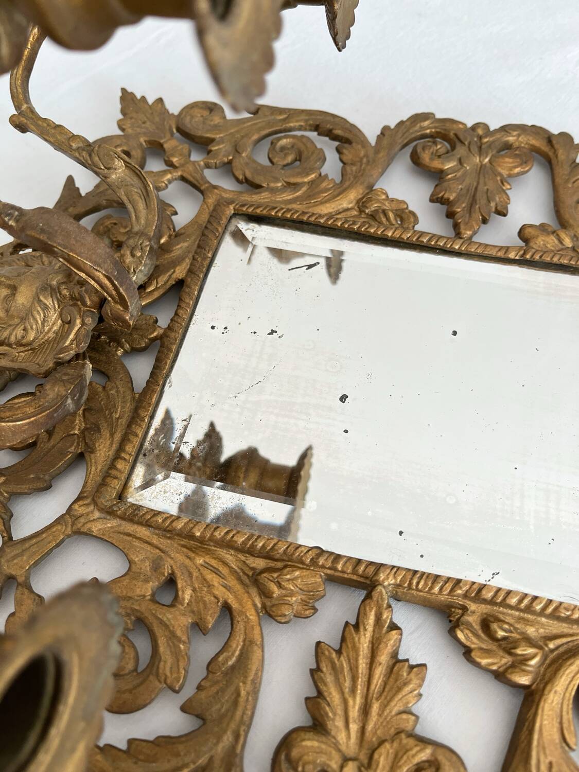 Bevelled mirror wall sconce in gilded bronze with 3 candle holders.
