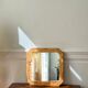 Octagonal mirror in light wood with grooves.