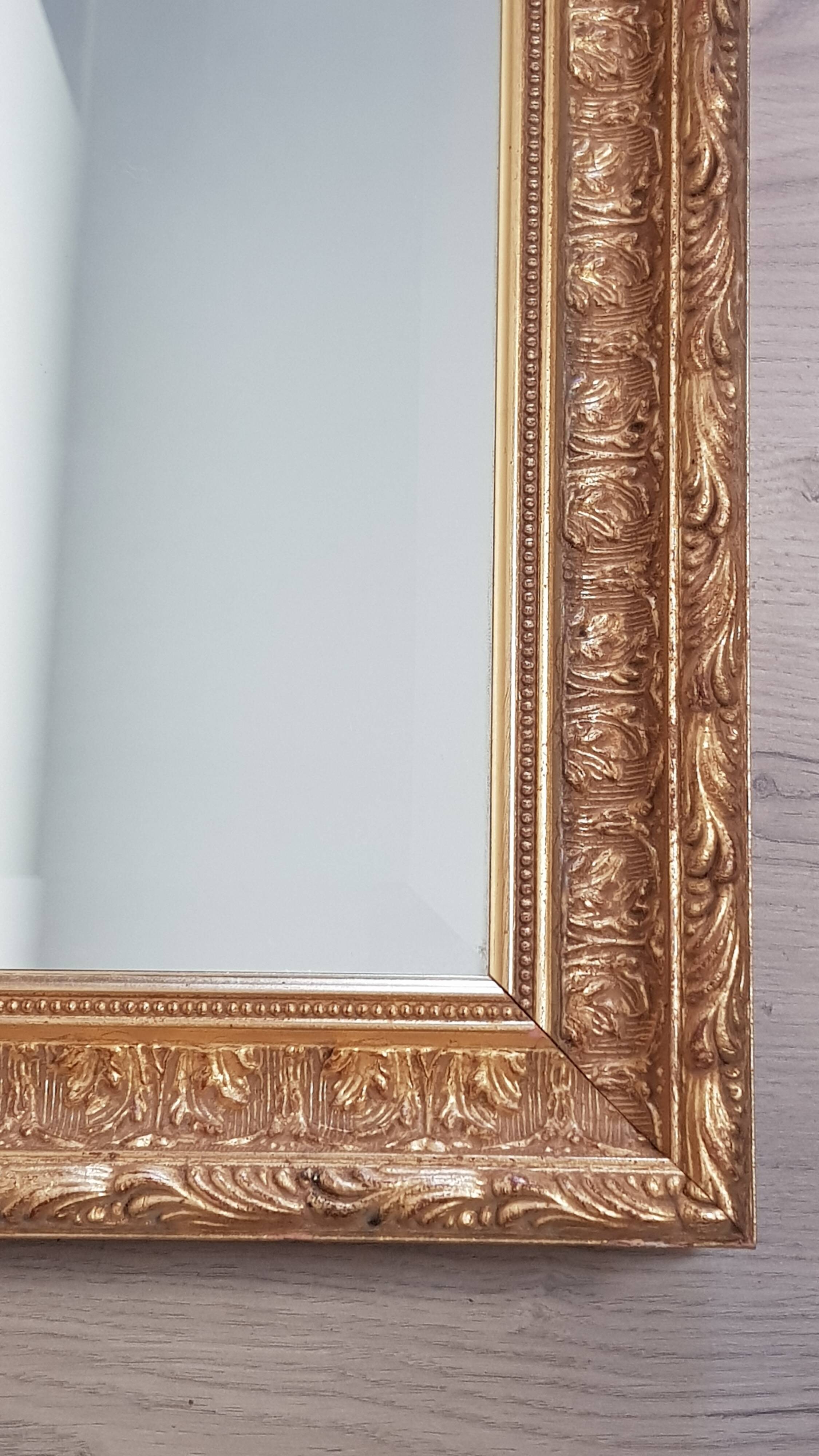 Mirror in gilded stucco wood and beveled glass