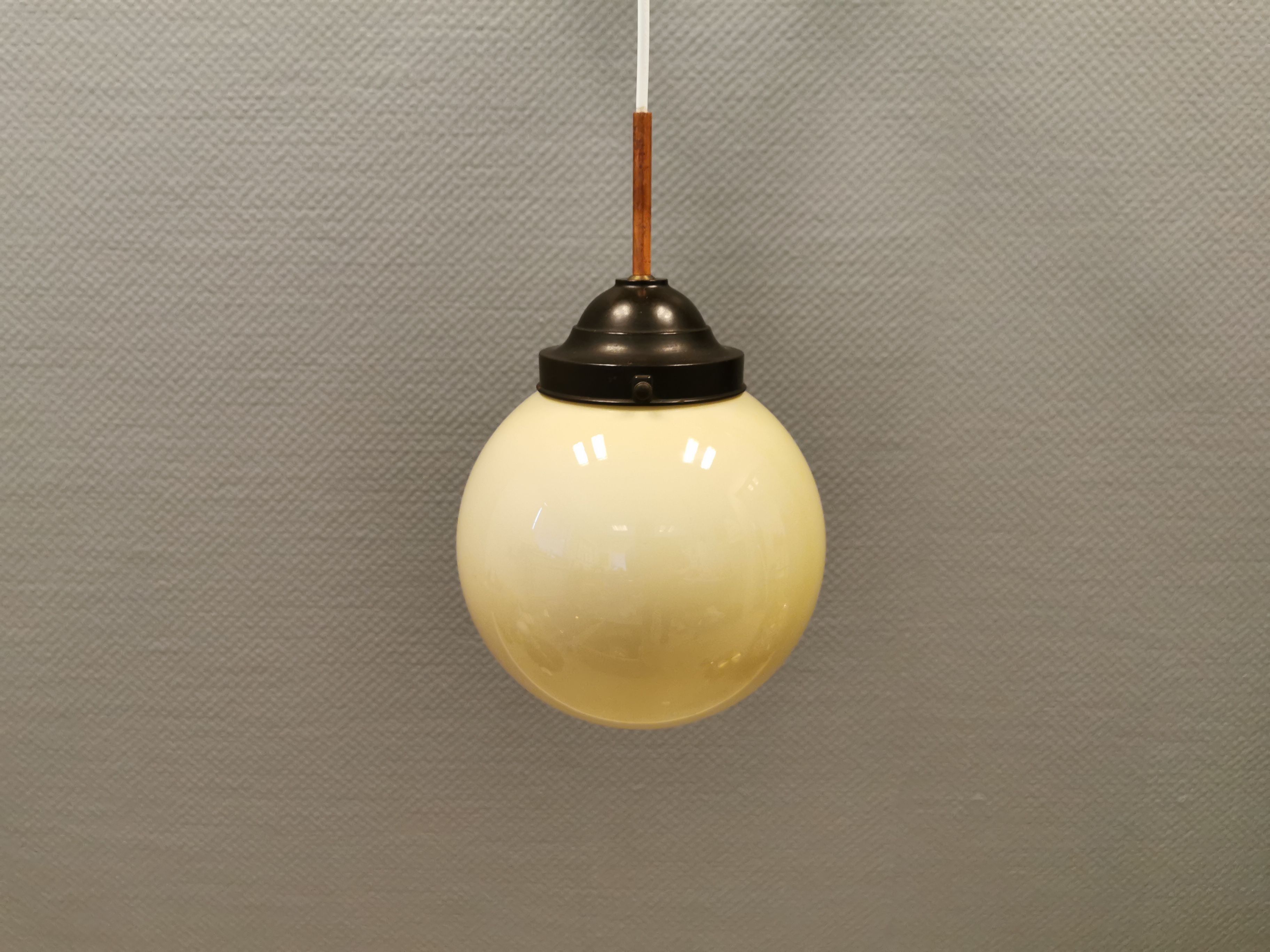 Small Art Deco hanging lamp in cream coloured glass and bakelite top.
