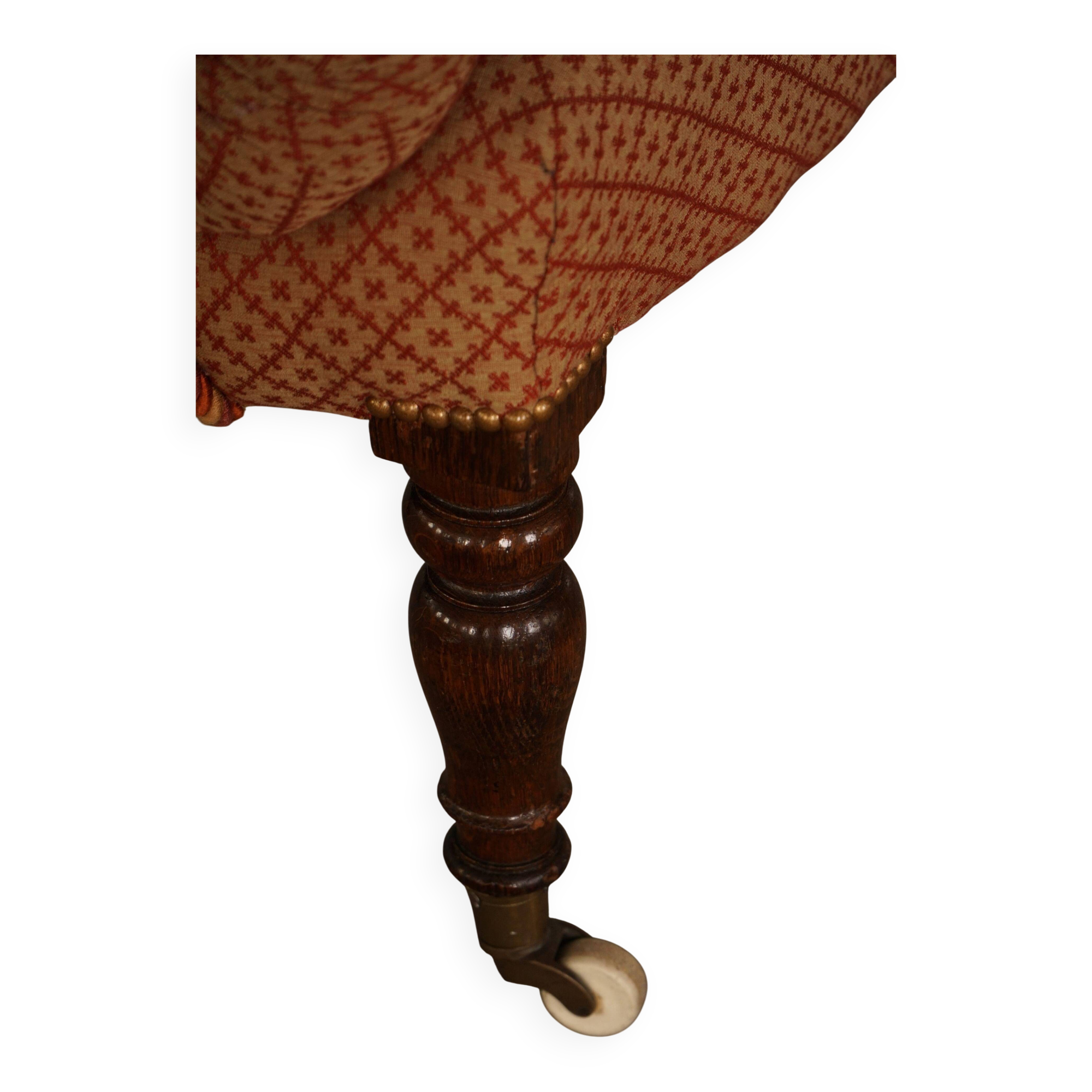 Victorian mahogany armchair, with wheels and coloured fabric, England, early 1900s.