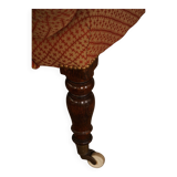 Victorian mahogany armchair, with wheels and coloured fabric, England, early 1900s.