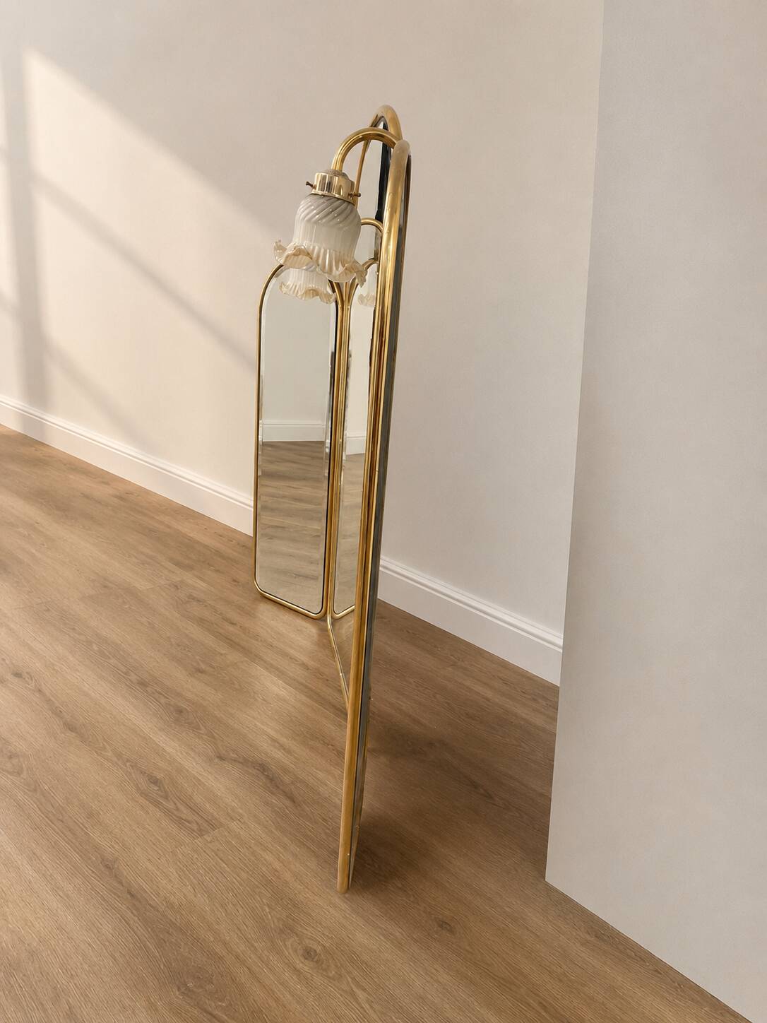 Vintage triptych mirror in brass with wall lights.