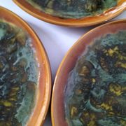 Set of 4 flamed enamel plates in green and amber from the 60s-70s.