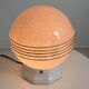 Art Deco lamp with a speckled pink glass globe and a white ceramic base.