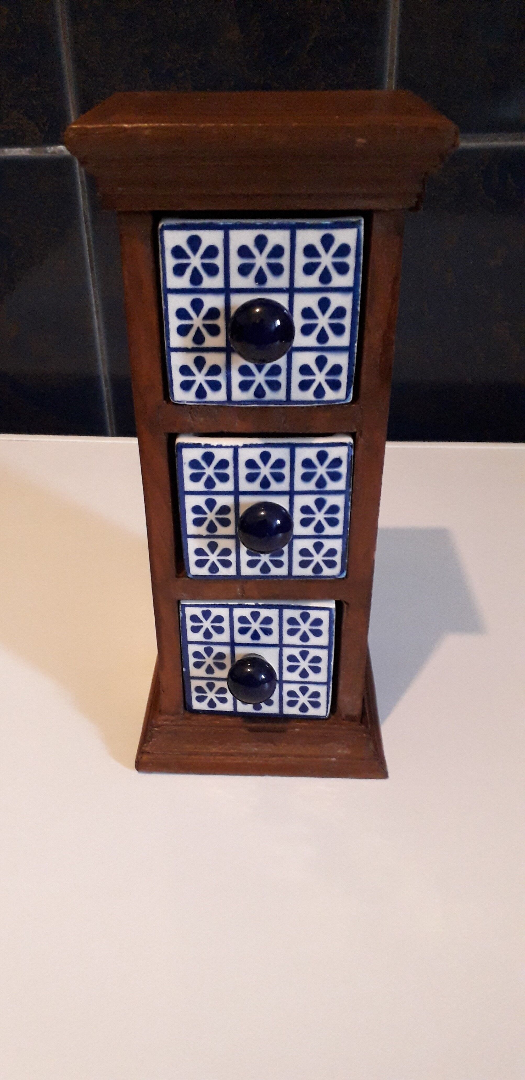 Storage in the form of a small wooden cabinet, with 3 ceramic drawers.