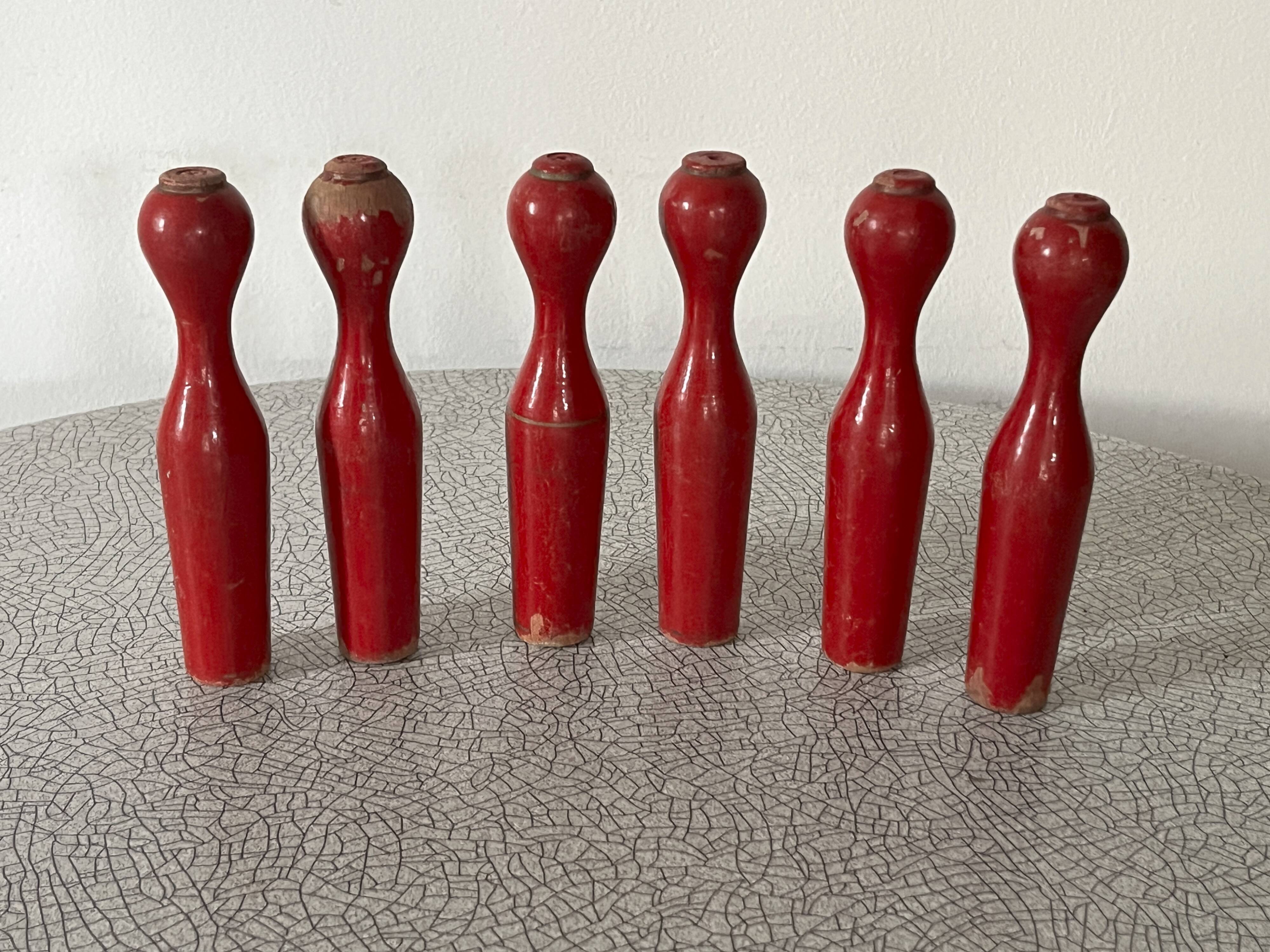 Set of old wooden bowling pins in red