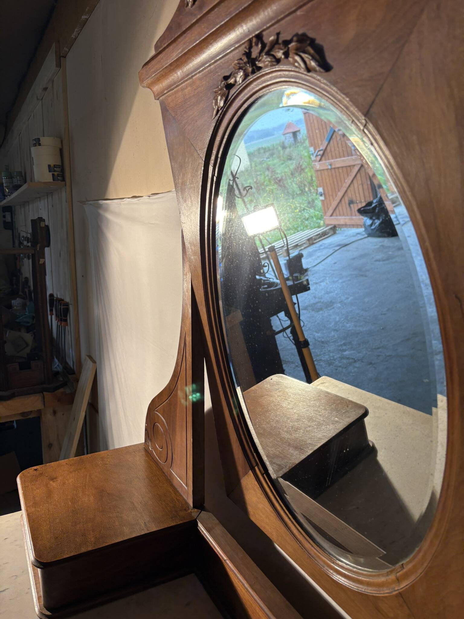 Antique carved wooden dressing table with marble and tilting oval mirror.