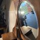 Antique carved wooden dressing table with marble and tilting oval mirror.