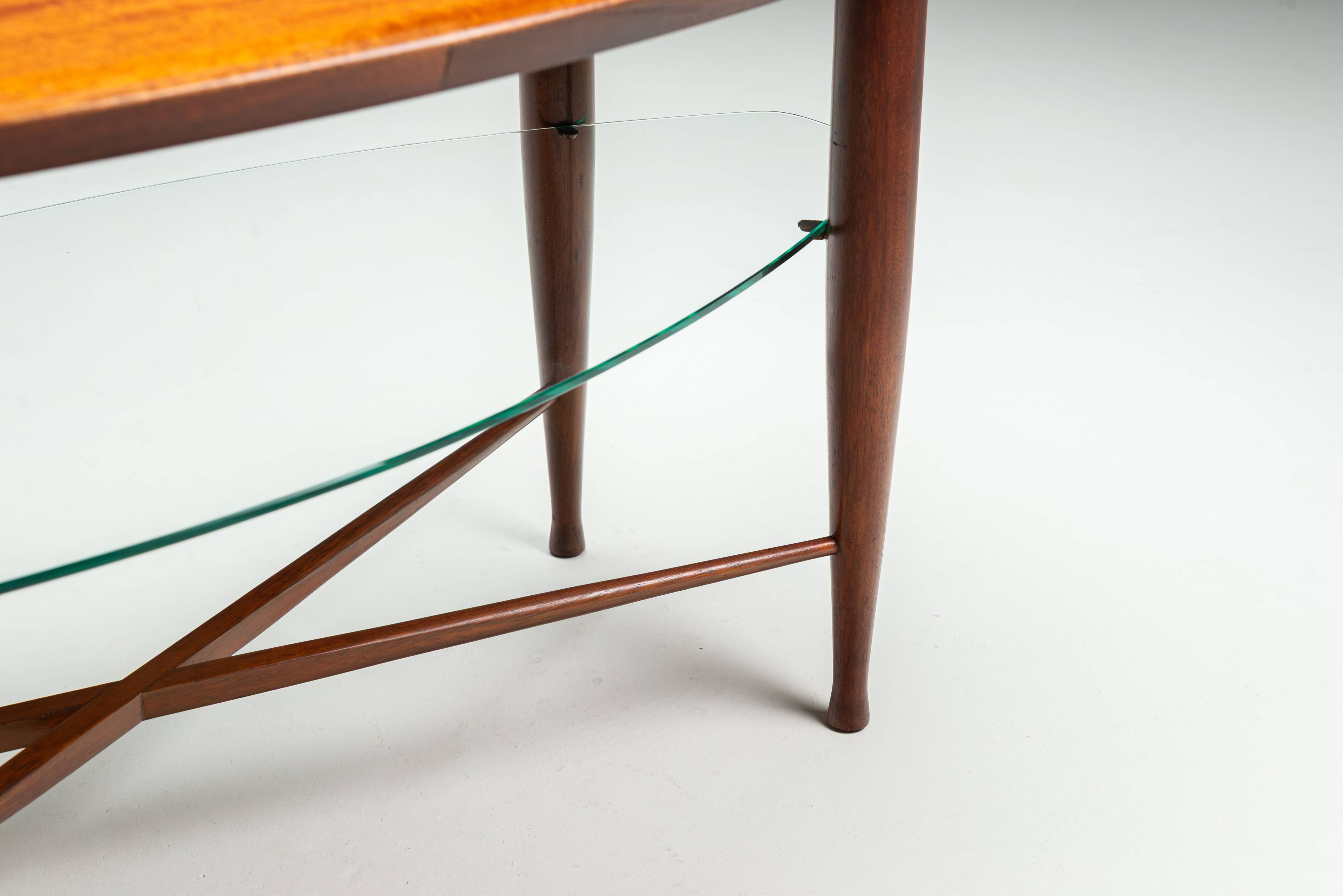 Assymetrical coffeetable with glass storage and cross leg details
