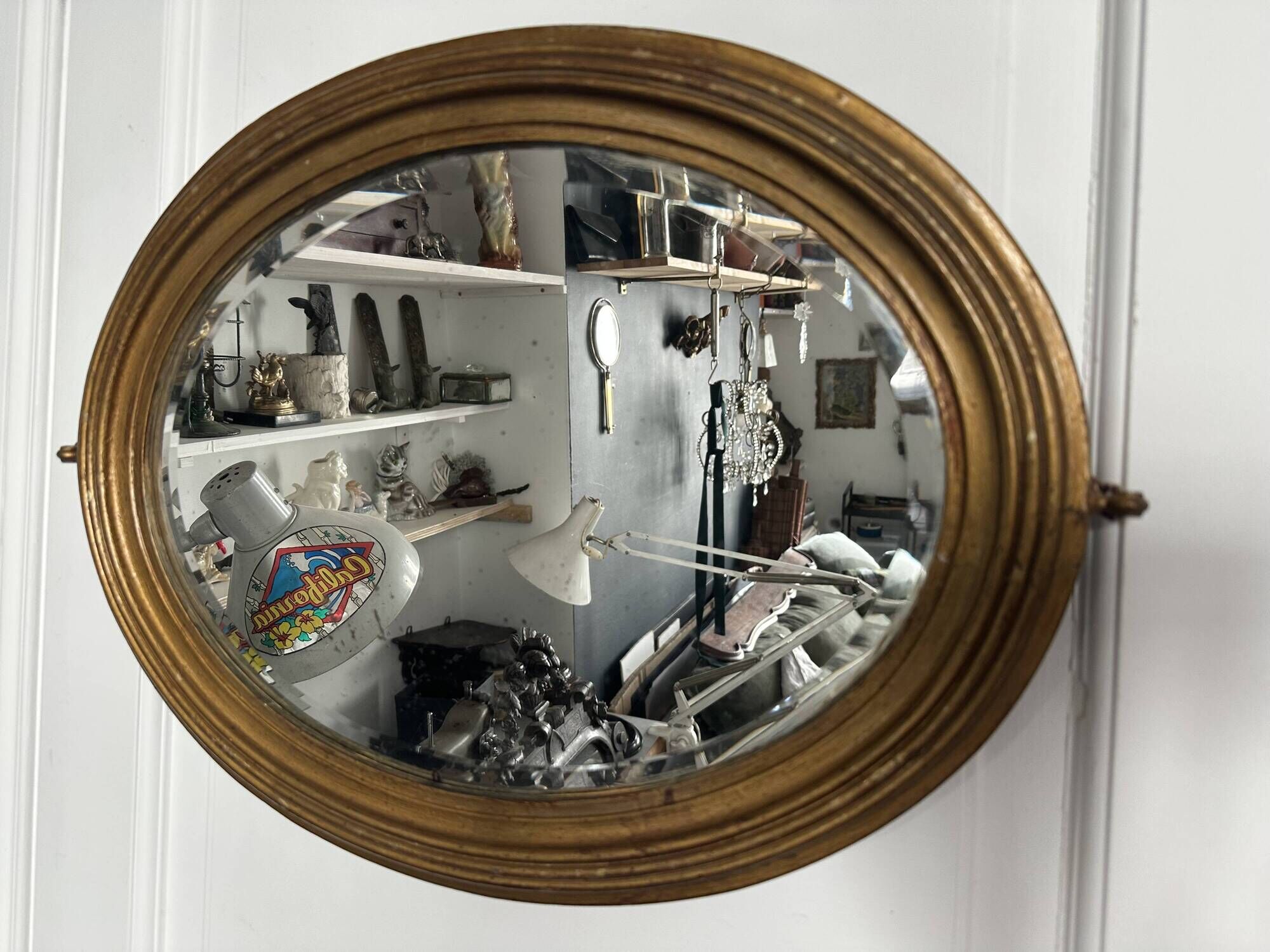 Antique oval mirror in gilded wood, bevelled mercury glass, 19th century.