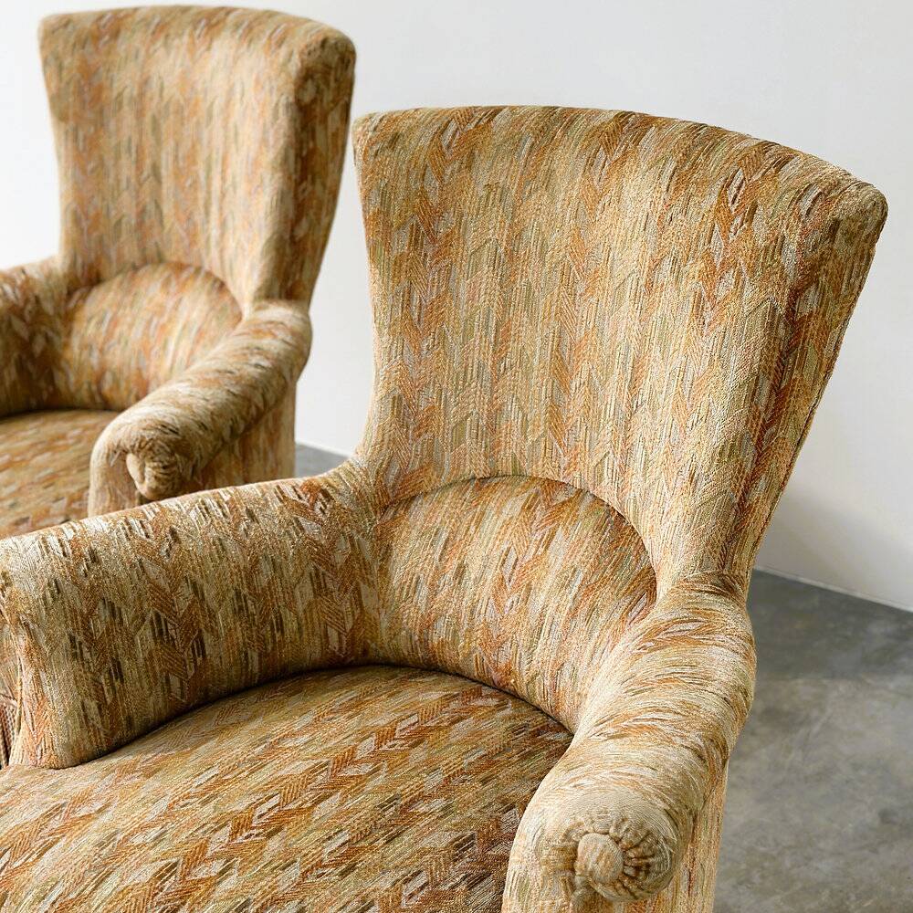 Pair of sculptural Hollywood Regency lounge chairs with original fringed upholstery