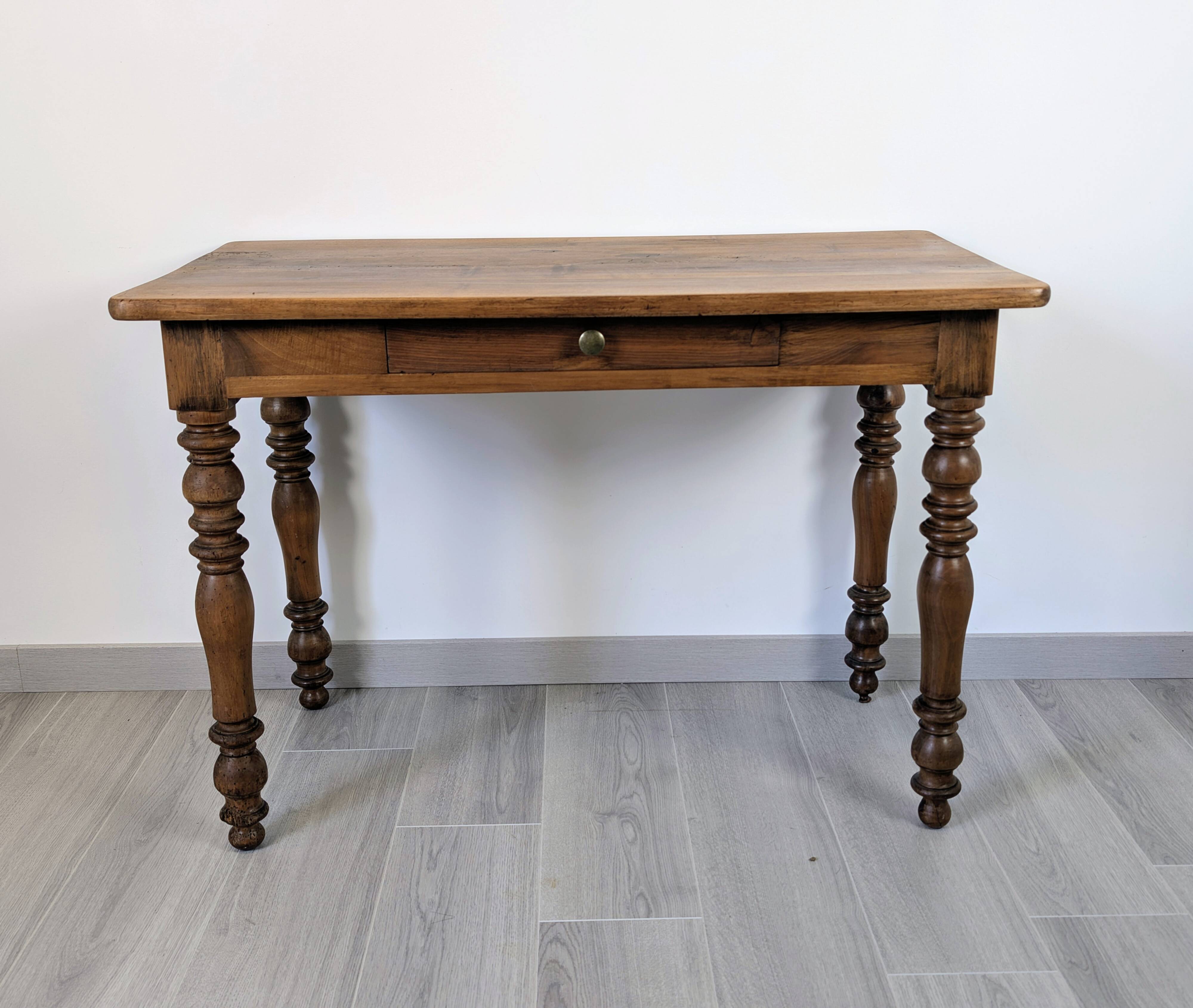 Antique writing table in the Napoleon III style with turned wooden legs.