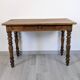 Antique writing table in the Napoleon III style with turned wooden legs.