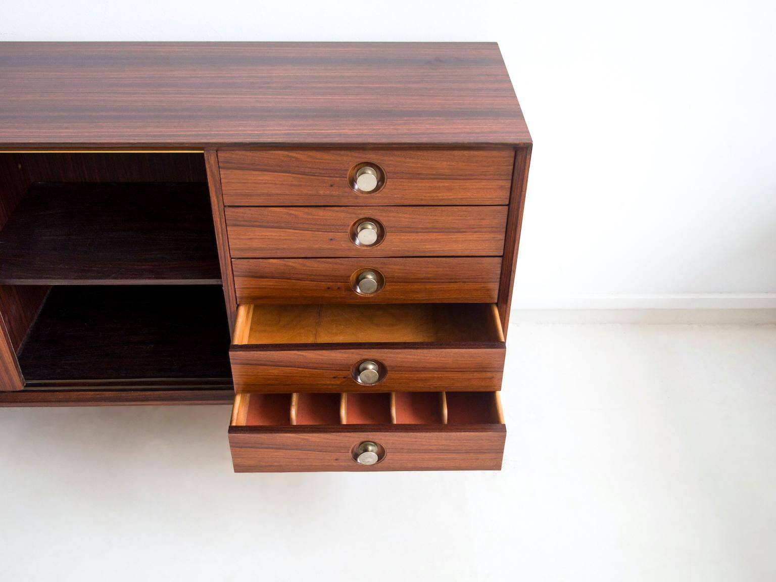 Wooden sideboard with sliding door and white drawers, around 1960.