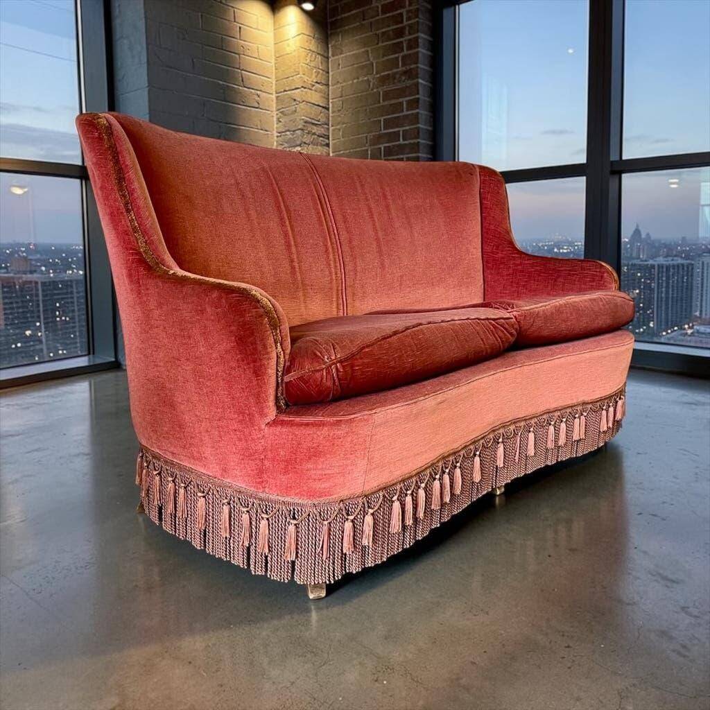 Vintage two-seater armchair in powder pink velvet with fringes.