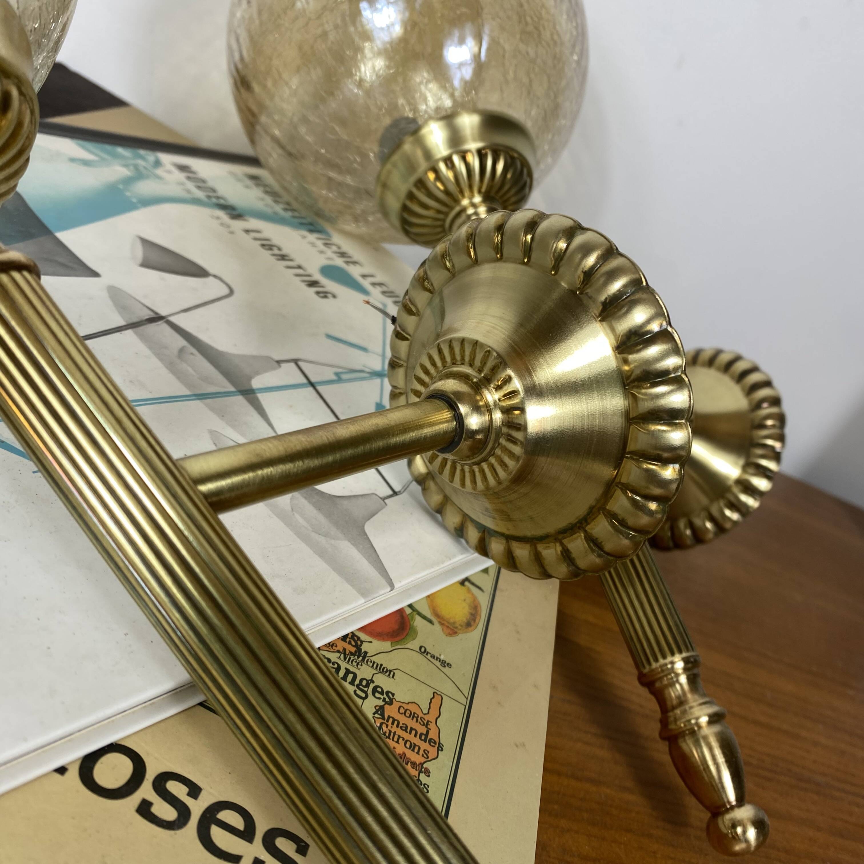 Pair of antique wall sconces torch style brass with glass globes in gold.