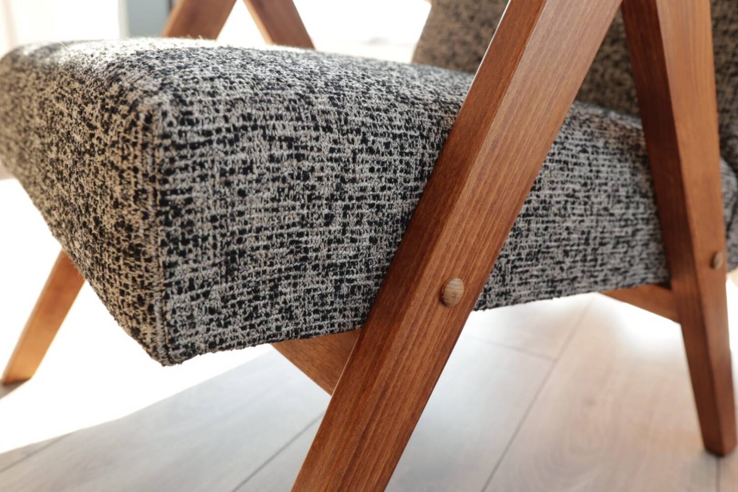 Vintage design armchair in mixed black fabric, walnut-coloured wood.