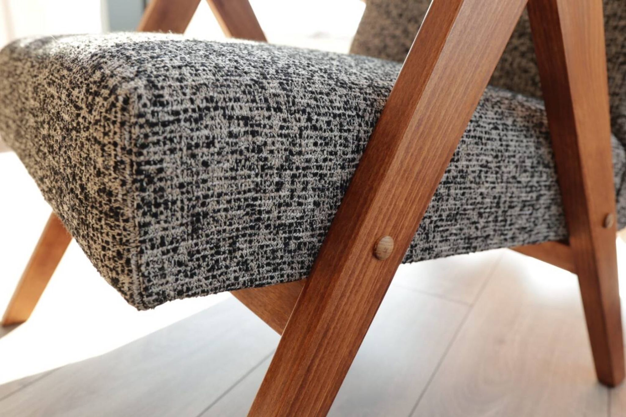 Vintage design armchair in mixed black fabric, walnut-coloured wood.
