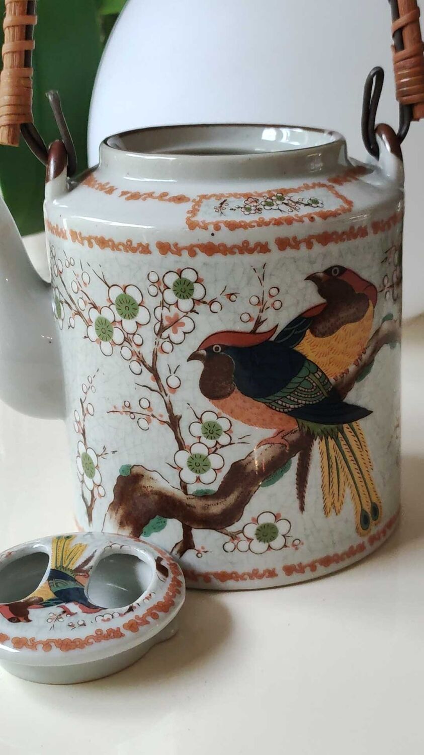 Japanese ceramic teapot. bird/paradise motifs/cherry trees. bamboo/rattan braided handle