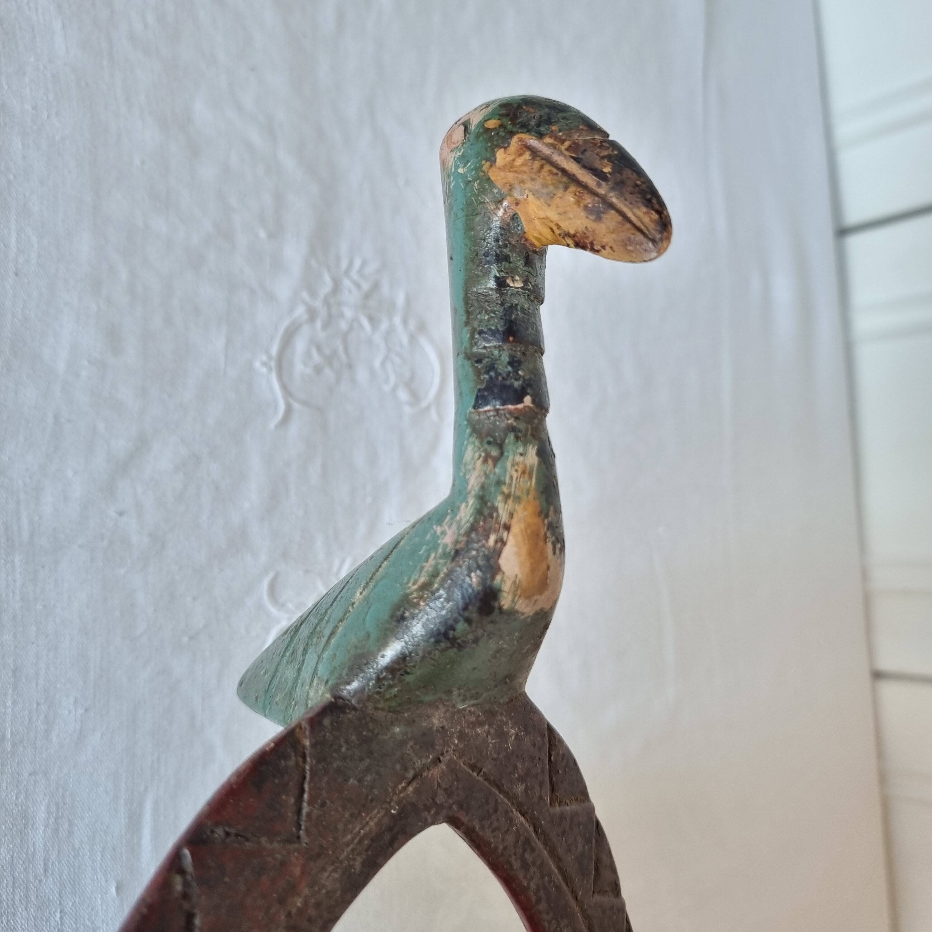 A large Senufo mask made of colored wood, decorated with an anthropomorphic figure