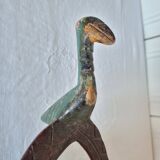 A large Senufo mask made of colored wood, decorated with an anthropomorphic figure