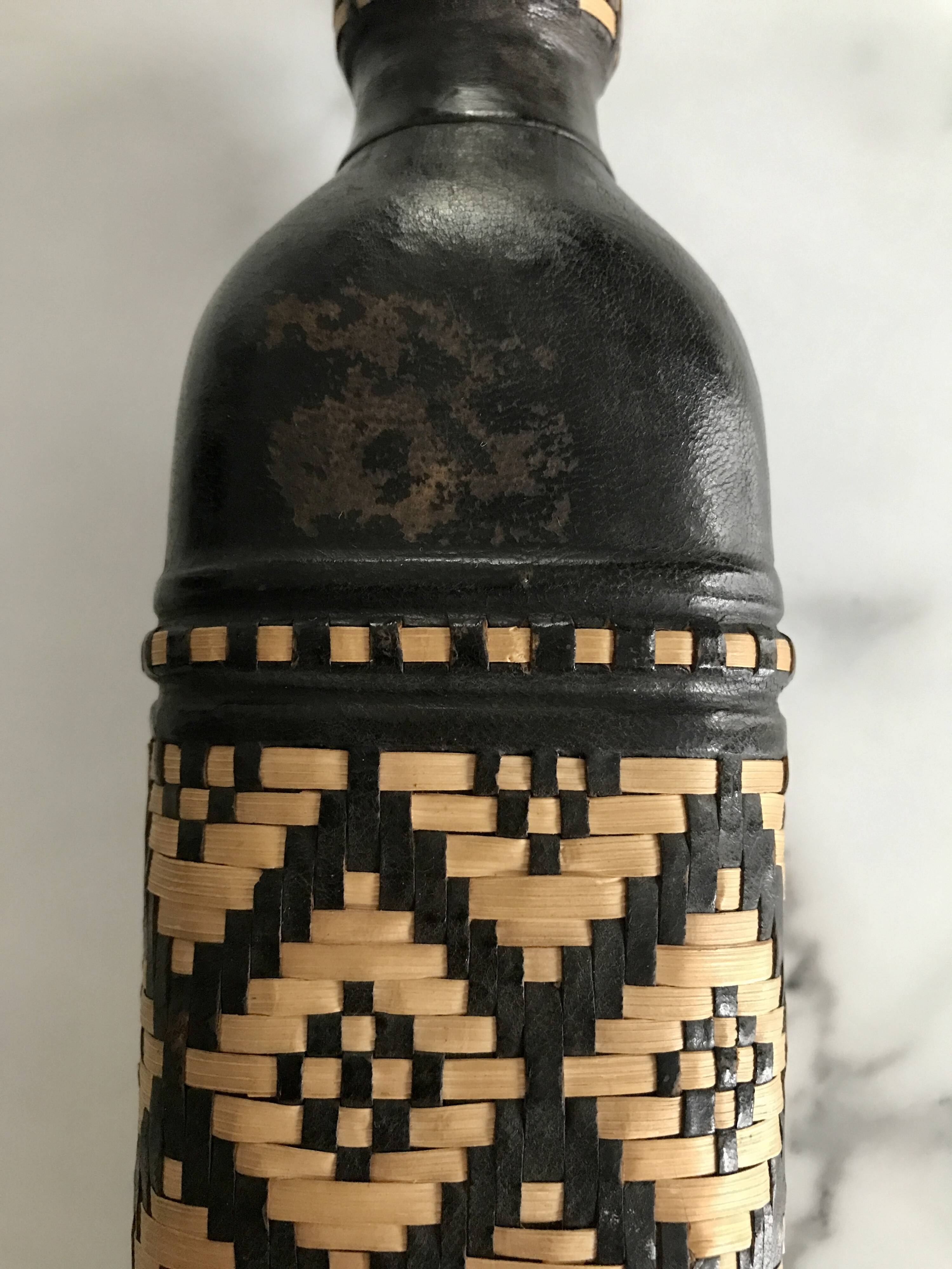 Ethnic decorative bottle in leather and raffia braiding