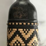 Ethnic decorative bottle in leather and raffia braiding