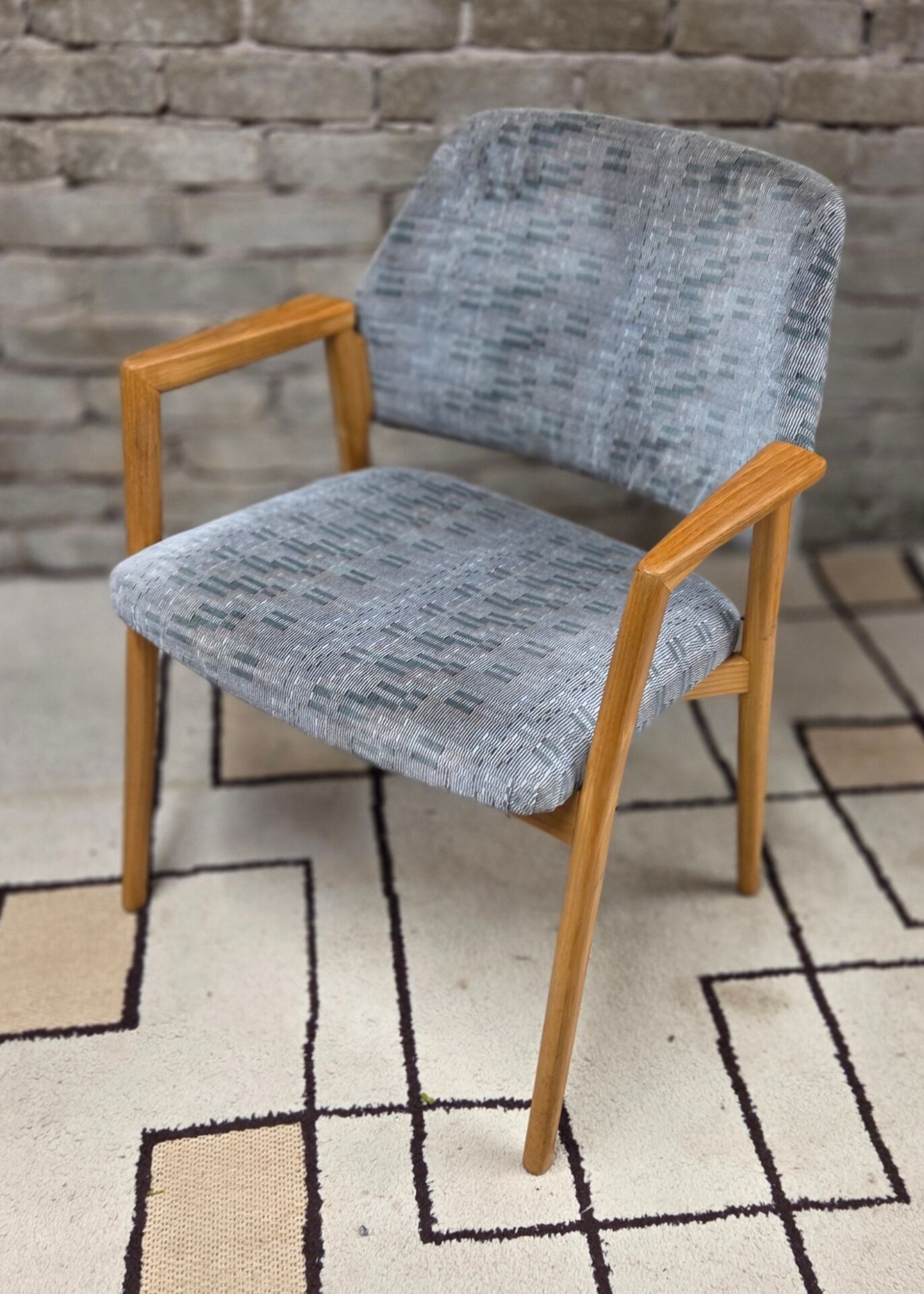 Vintage armchair from the 60s/70s in wood and grey fabric – with armrests.