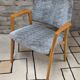 Vintage armchair from the 60s/70s in wood and grey fabric – with armrests.
