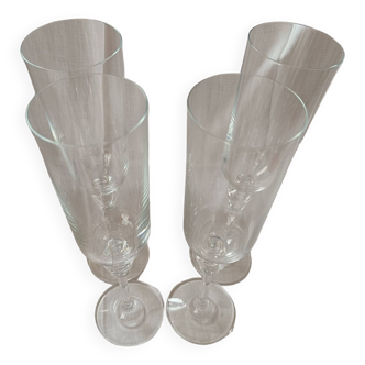 4 crystal champagne flutes with feet decorated with two knots.
