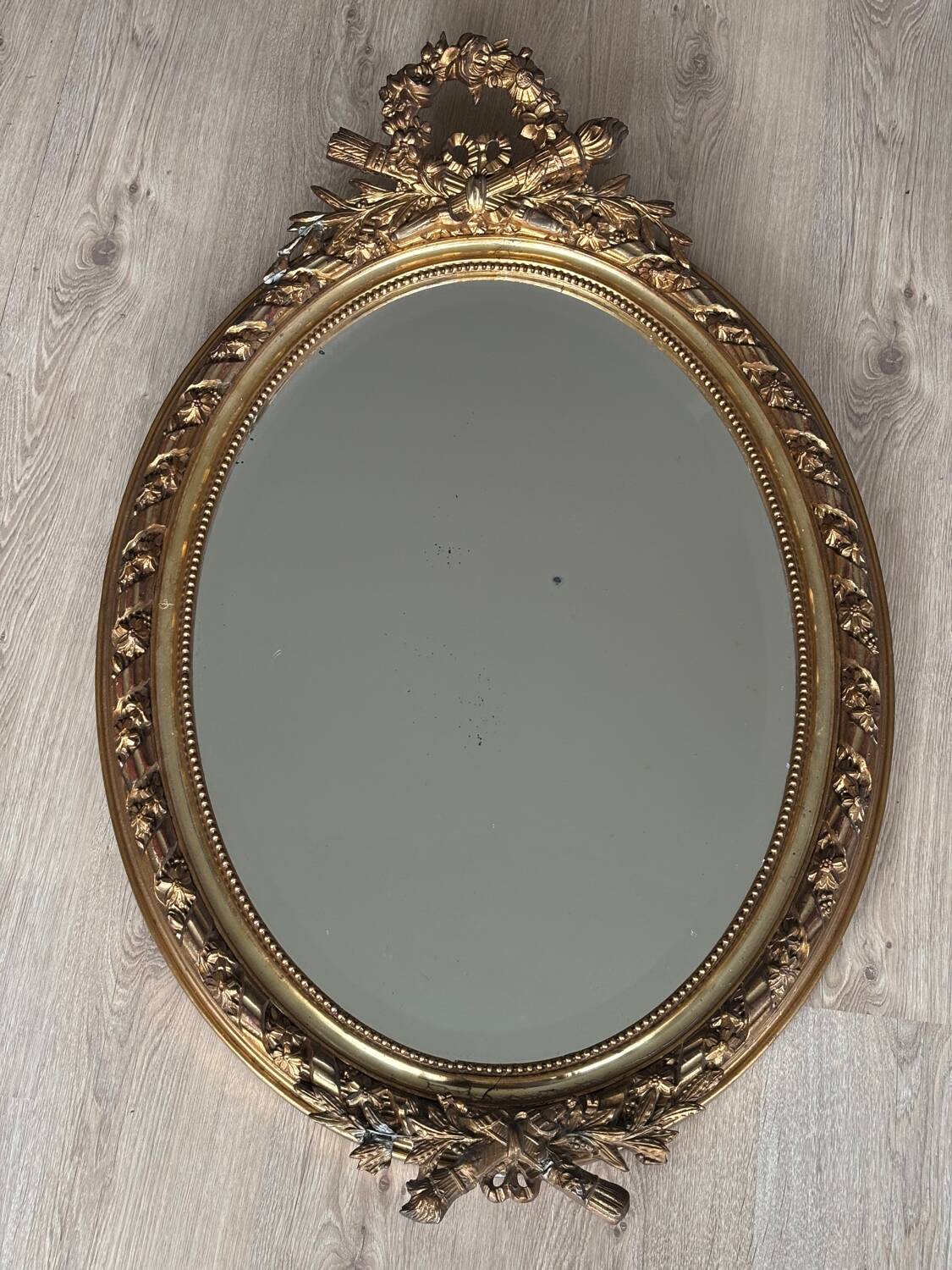 19th century oval gilded mirror, torch & quiver 106cm