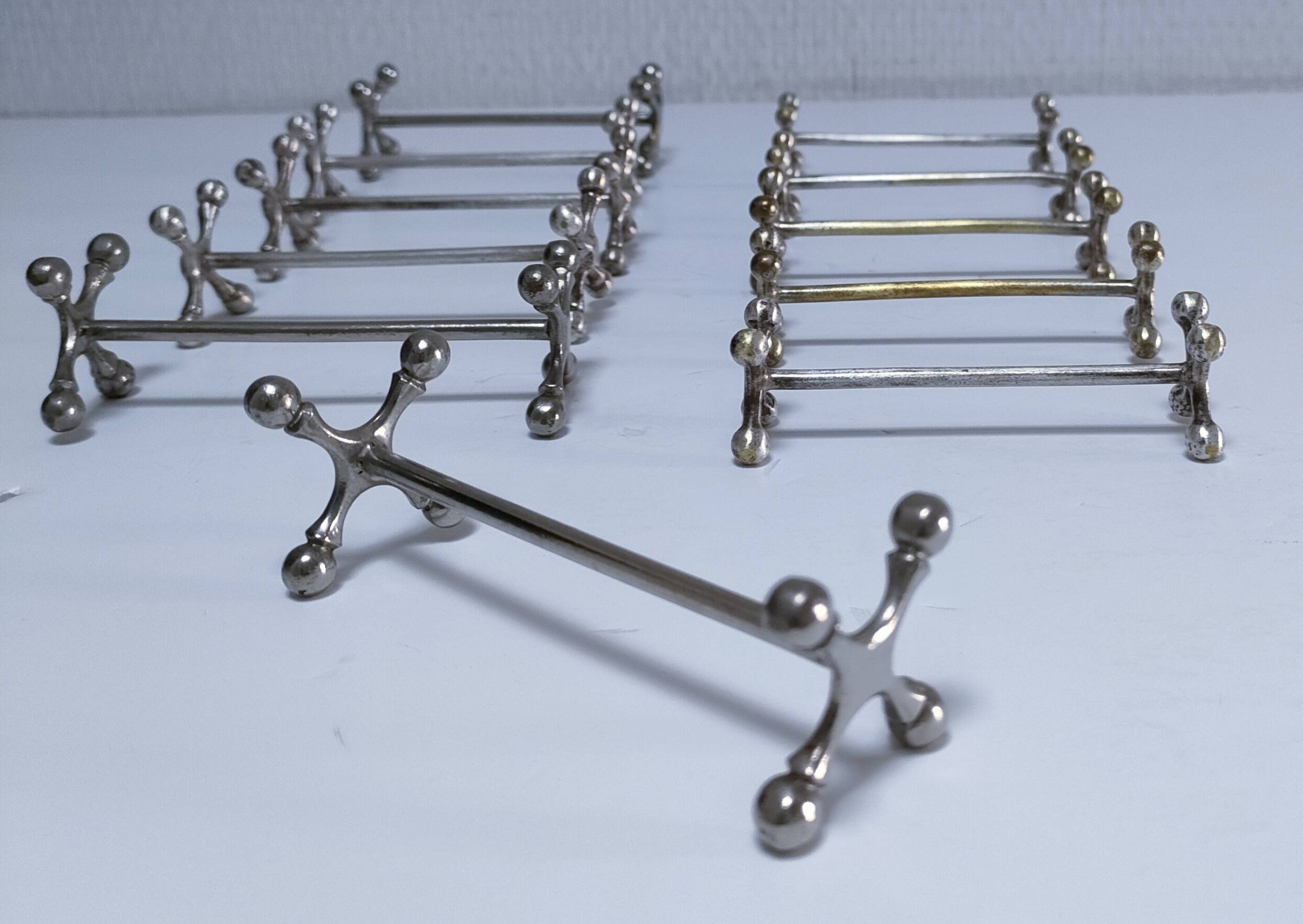 Eleven 70s design metal "crosshair" knife holders