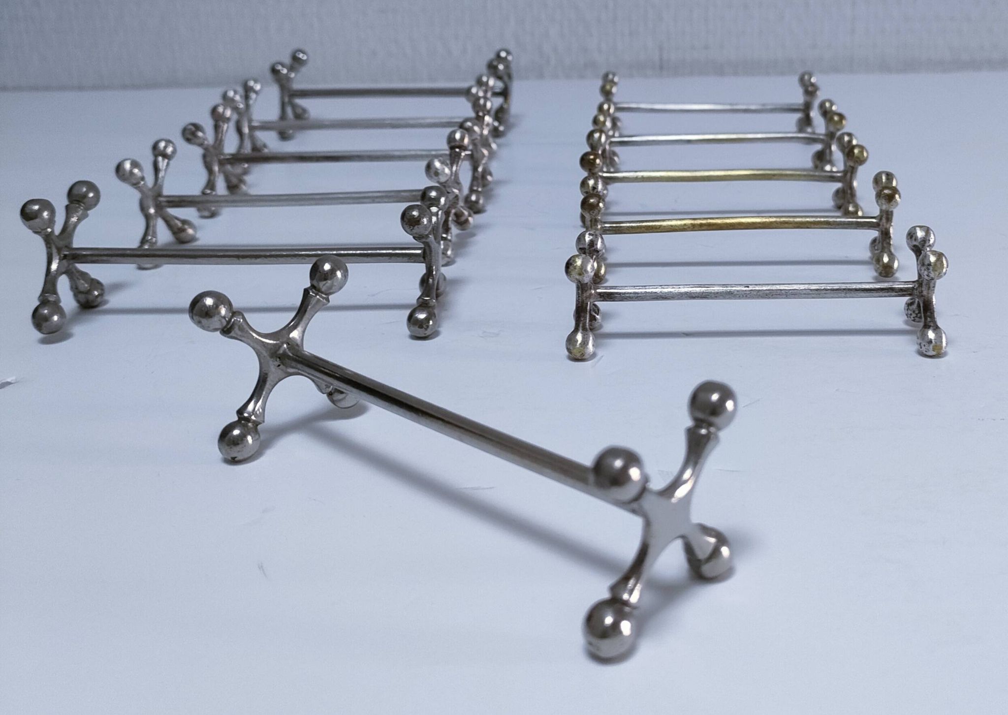 Eleven 70s design metal "crosshair" knife holders