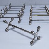 Eleven 70s design metal "crosshair" knife holders