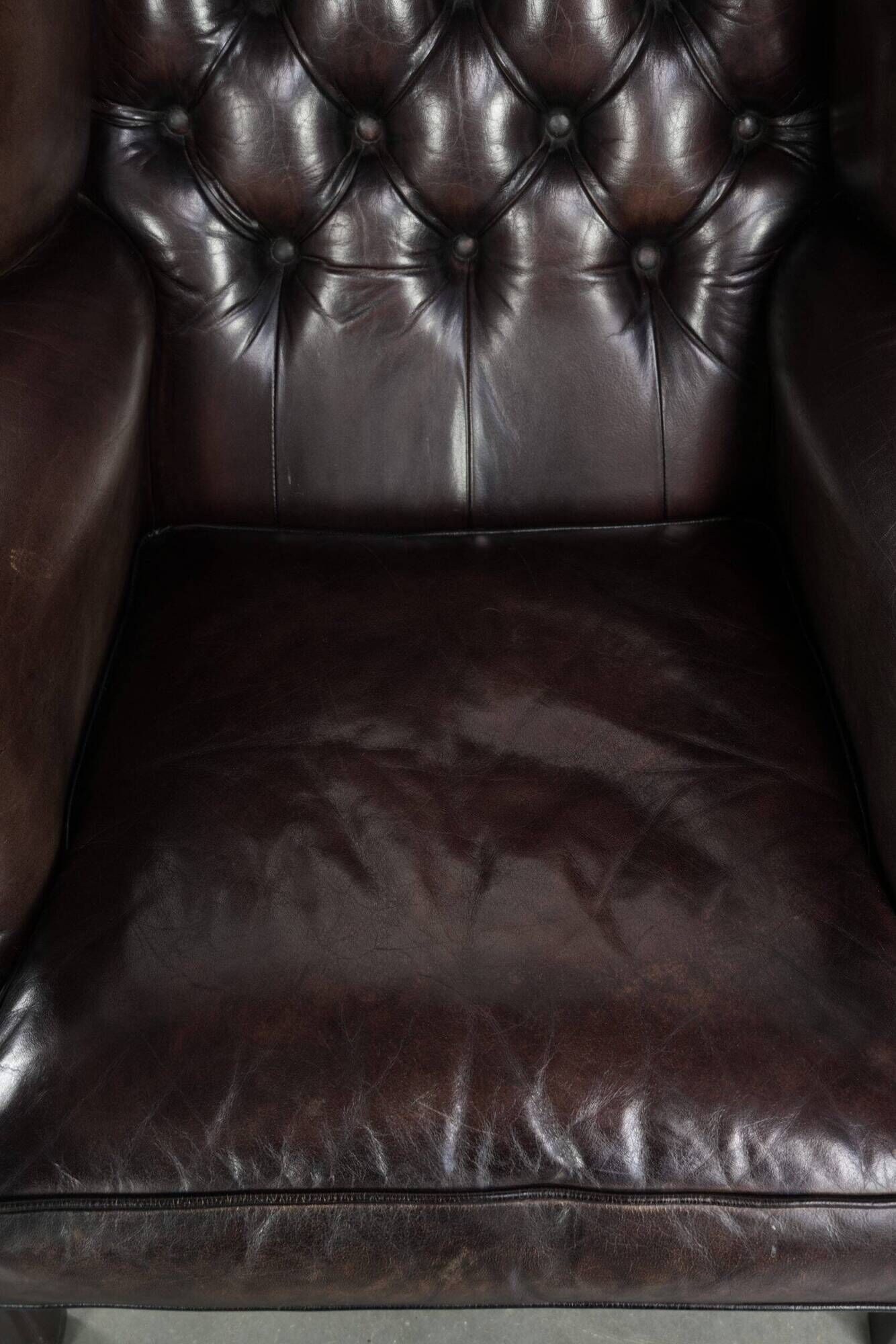 Dark brown cowhide Chesterfield wingback armchair in classic English style