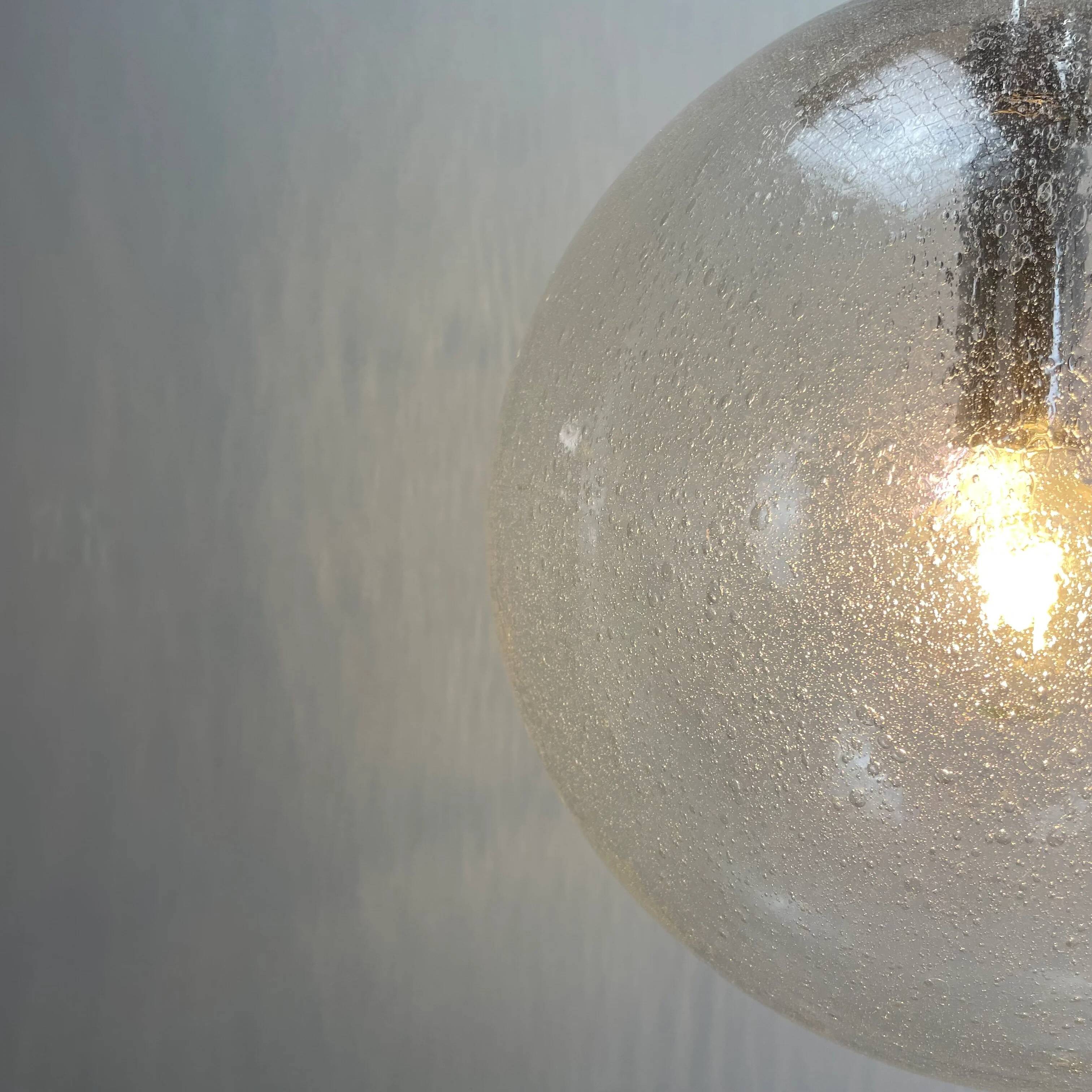 Large suspended lamp with a glass globe featuring bubbles by Peill & Putzler 1970.