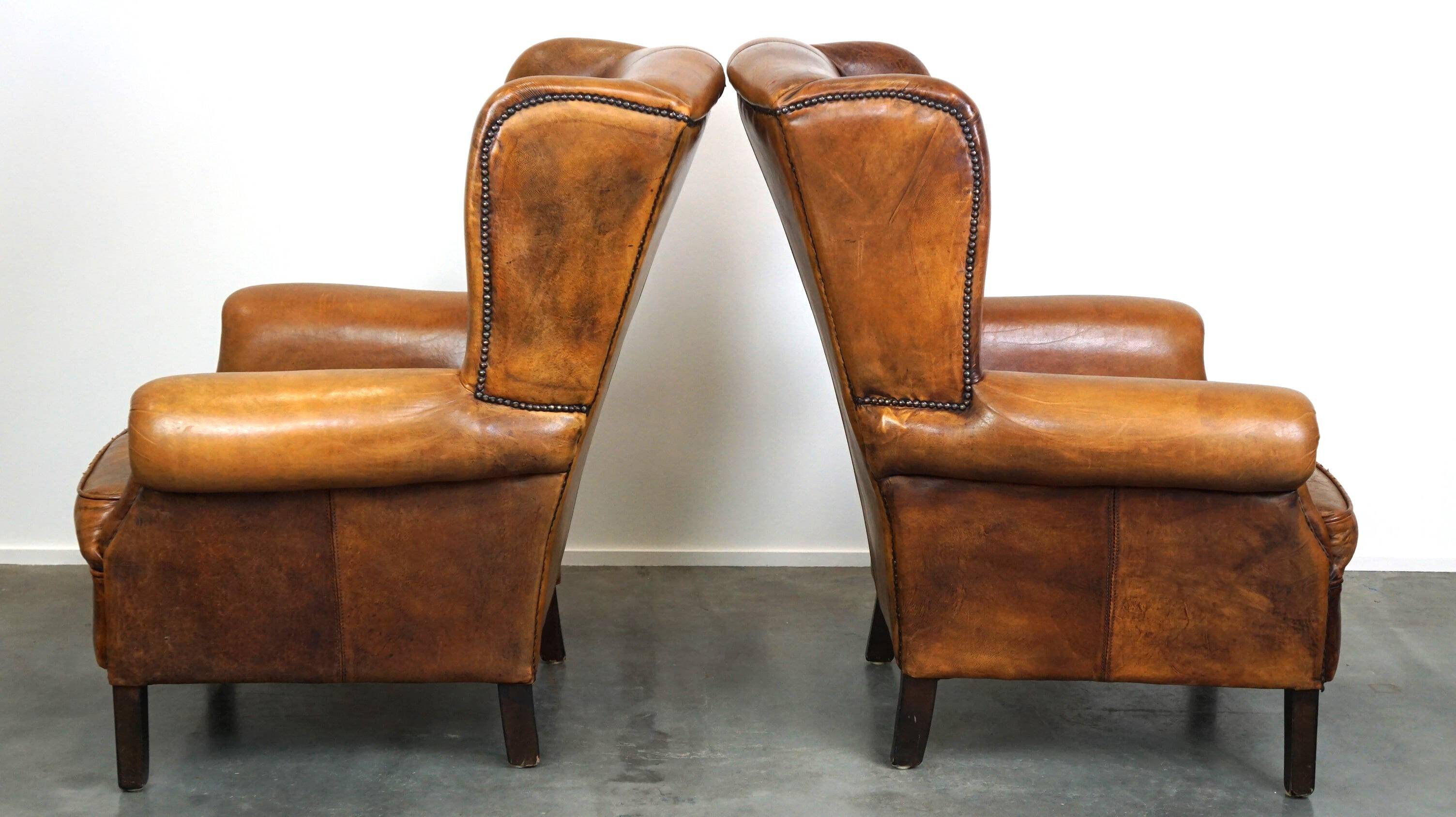Set of 2 beautiful and correct sheep leather wingback armchairs with fixed seat cushions