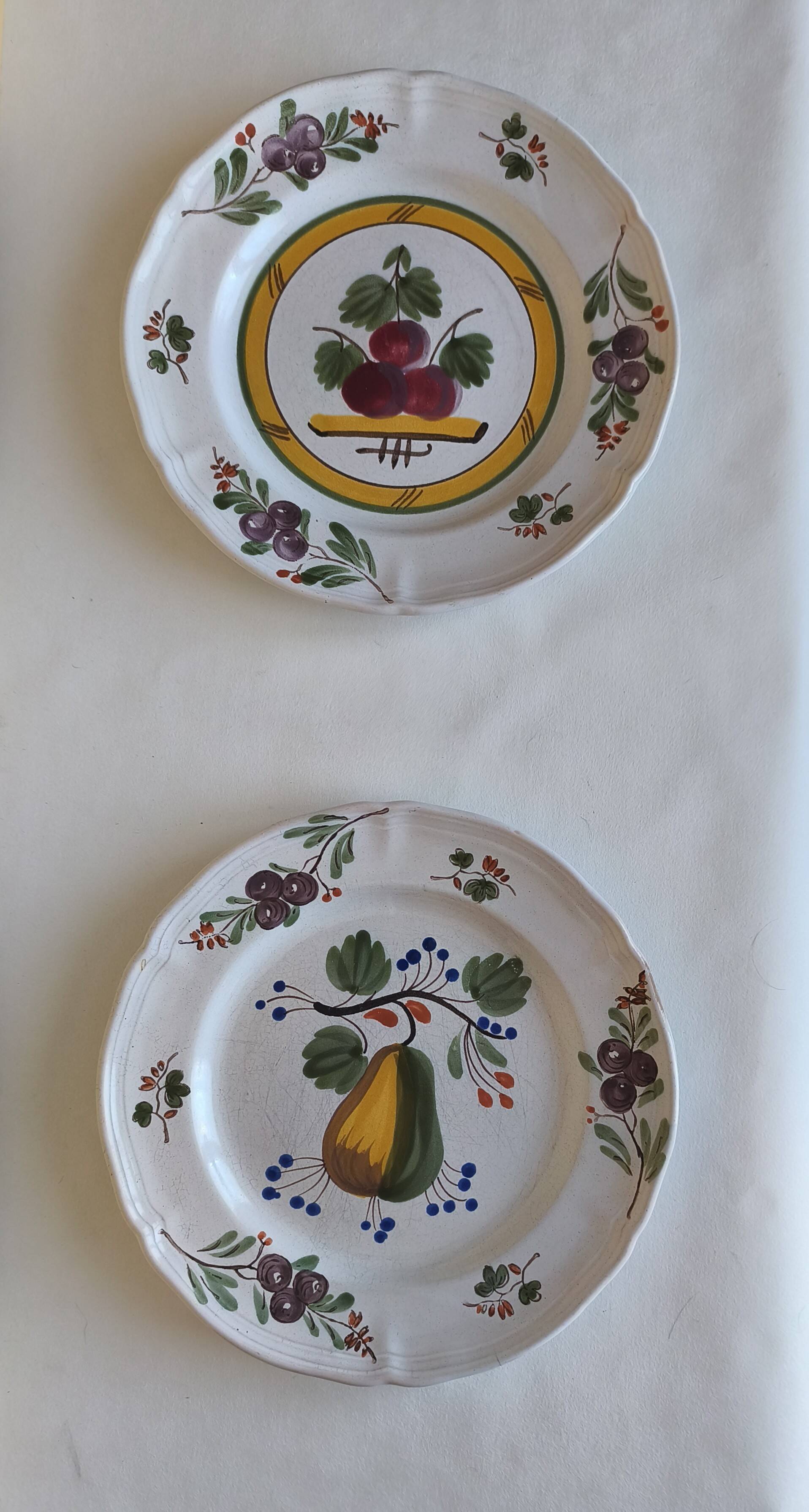Two earthenware plates with fruits, pears and plums.