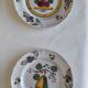 Two earthenware plates with fruits, pears and plums.