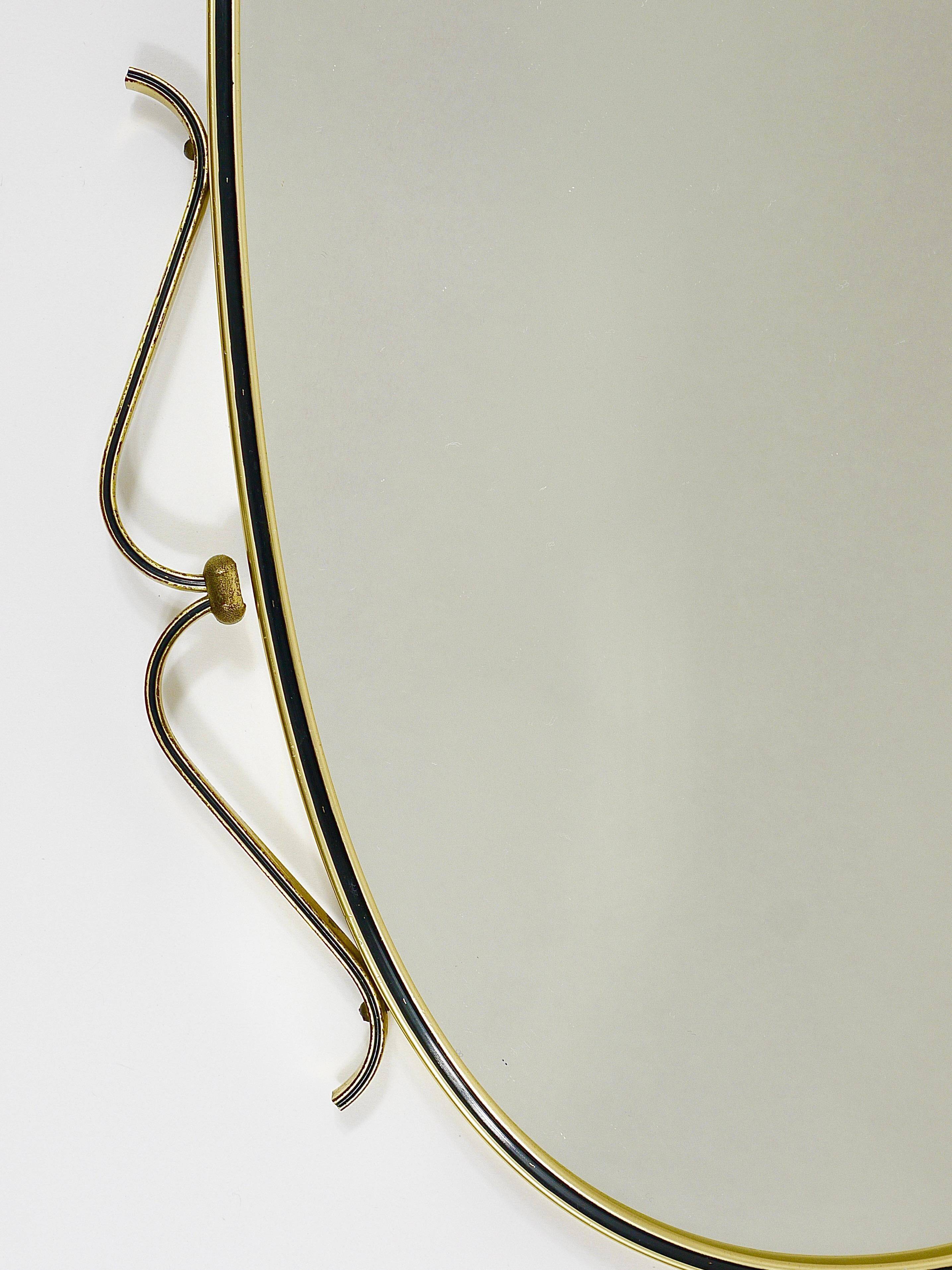 Elegant wall mirror in brass and black from the mid-century, Italy, 1950s.