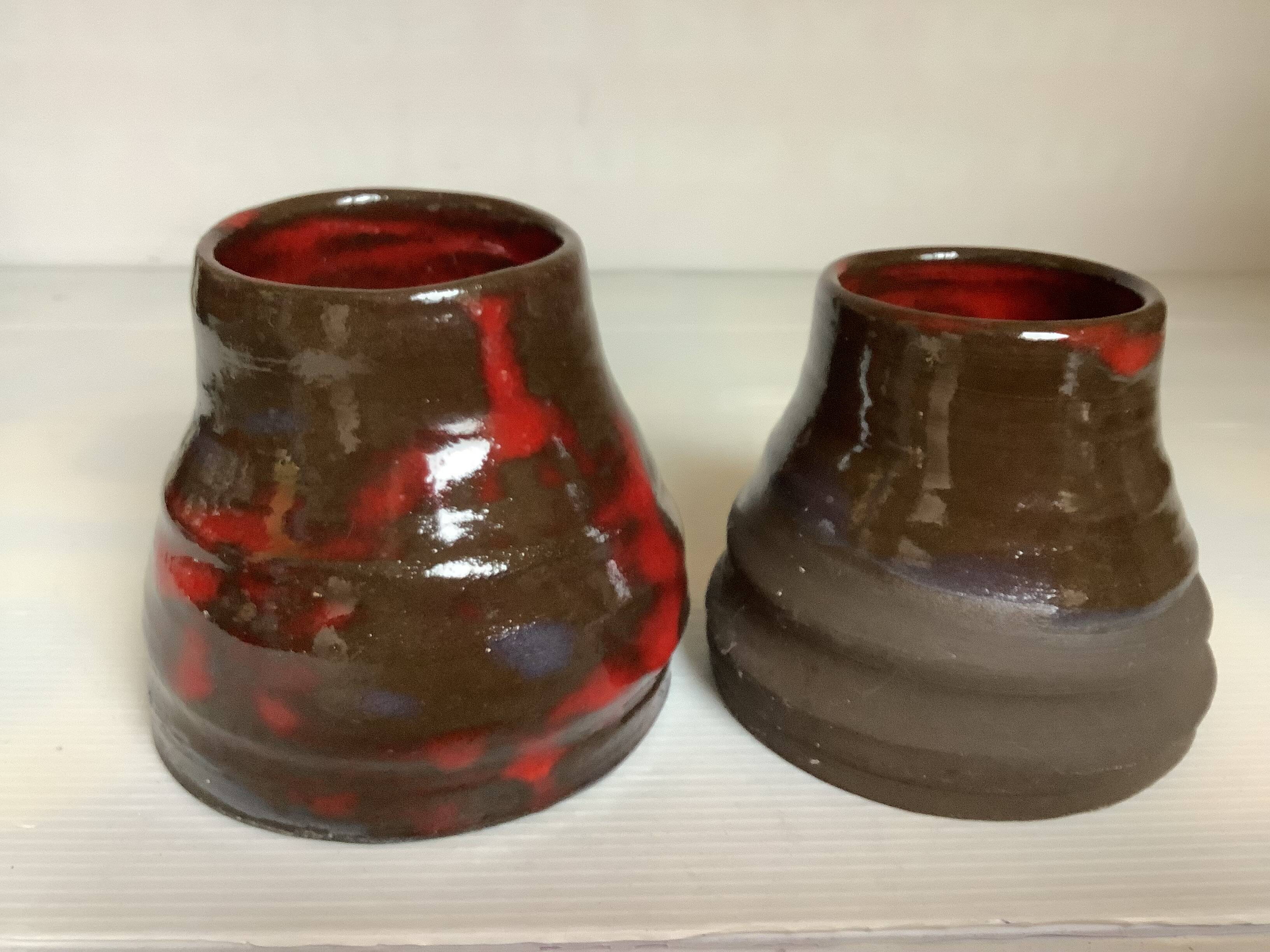 Pair of red vases in the shape of an elephant's foot