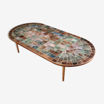 Table basse en carreaux de faience gravée de diverses couleurs.