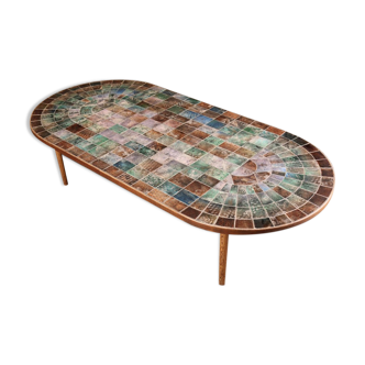 Table basse en carreaux de faience gravée de diverses couleurs.