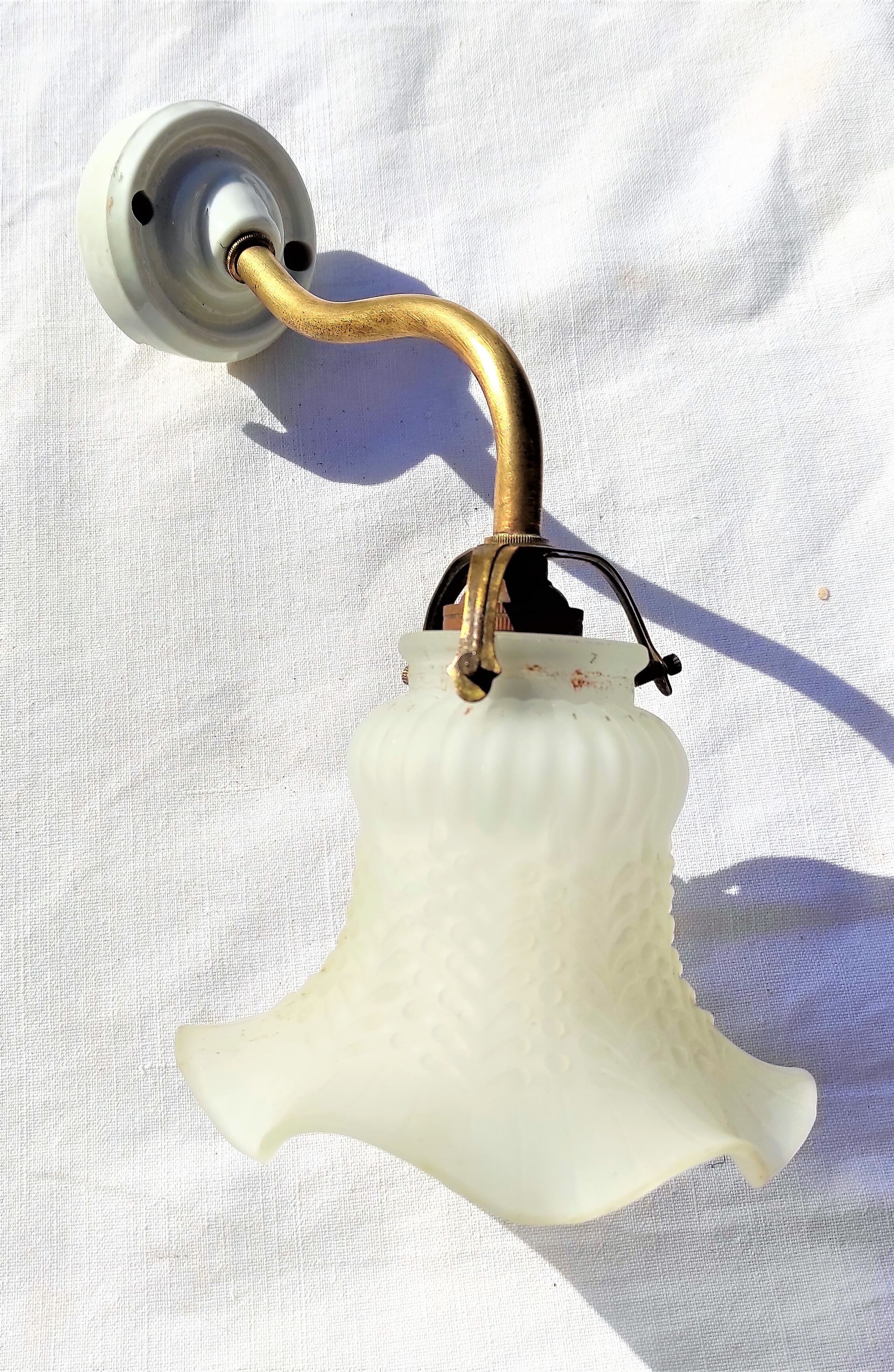 Brass gooseneck wall lamp, with brass socket and porcelain base.