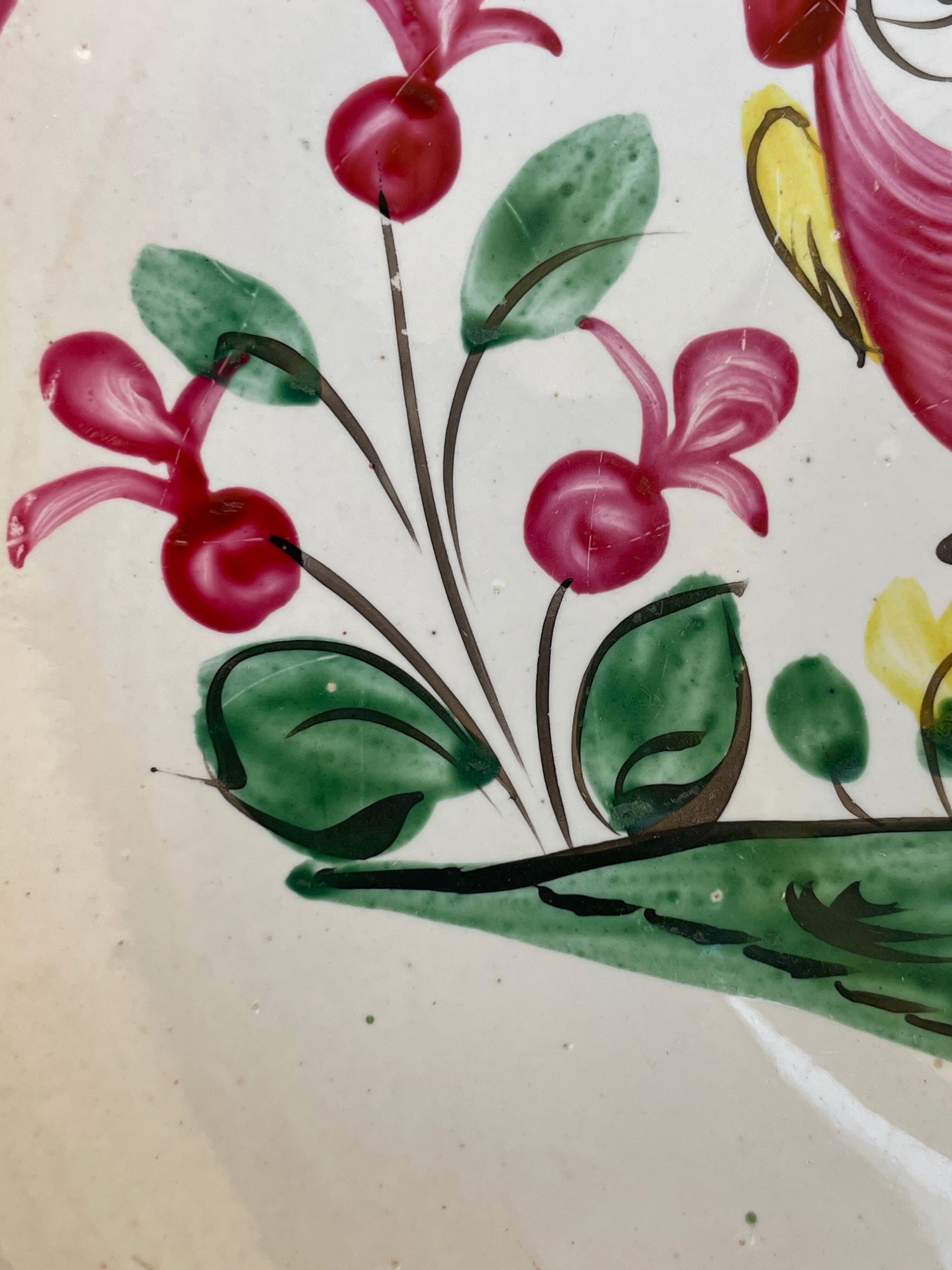 Antique plate with a flower and rooster pattern.