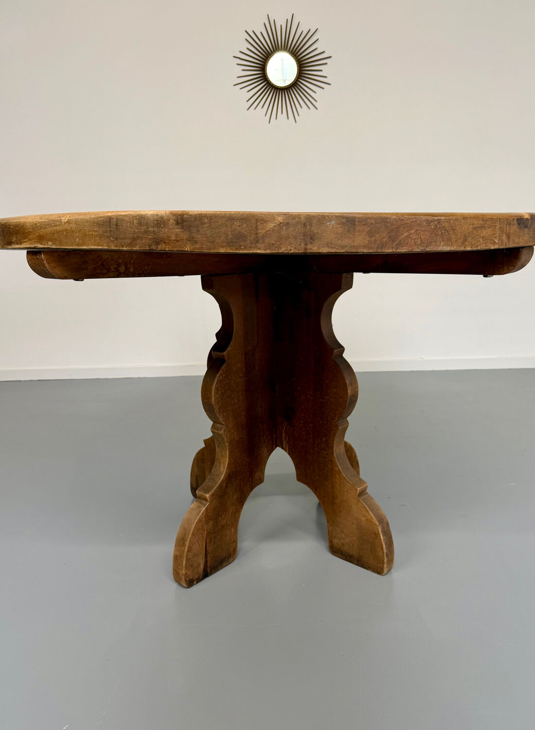 Round table in solid wood, thick top, vintage brutalist style from the 1960s.